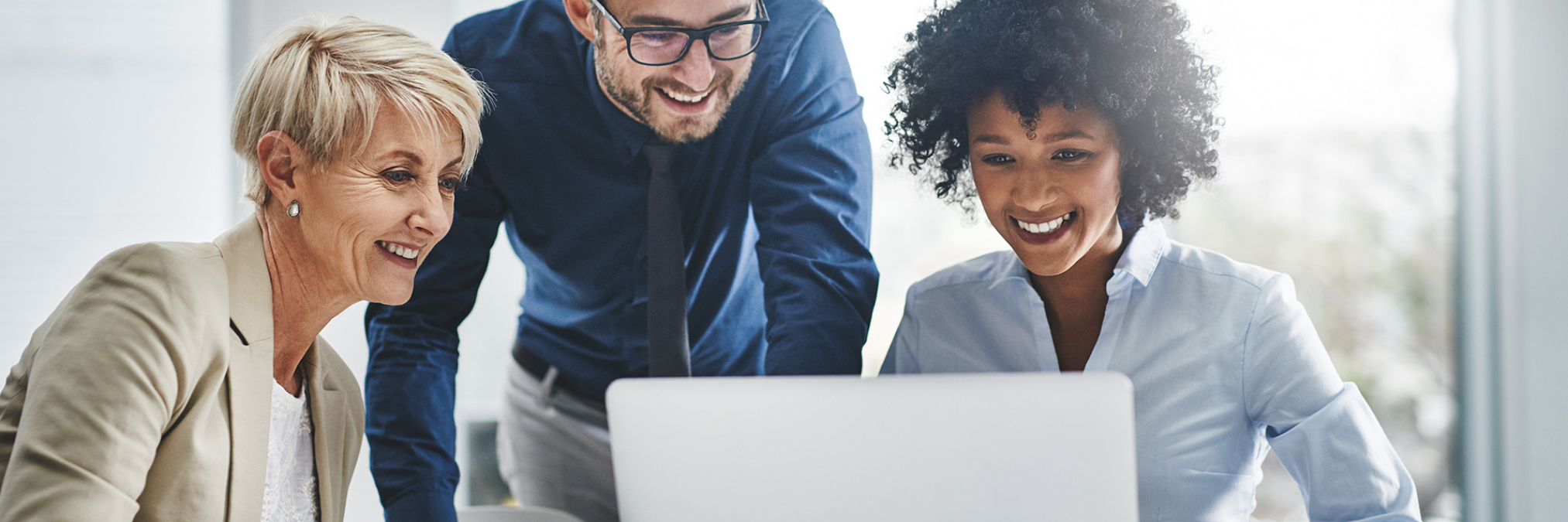 Three people looking at a laptop