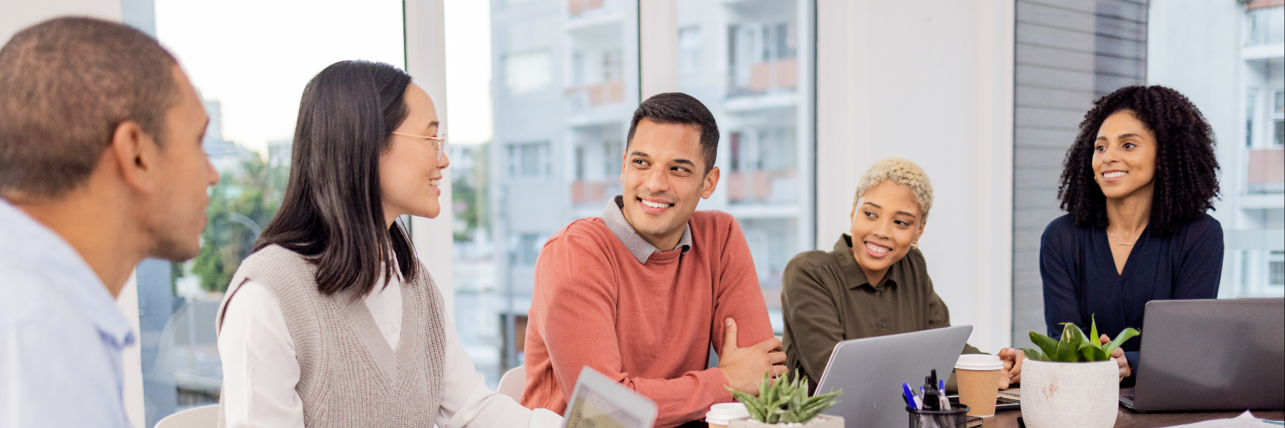 Five people on laptops in a conference room
